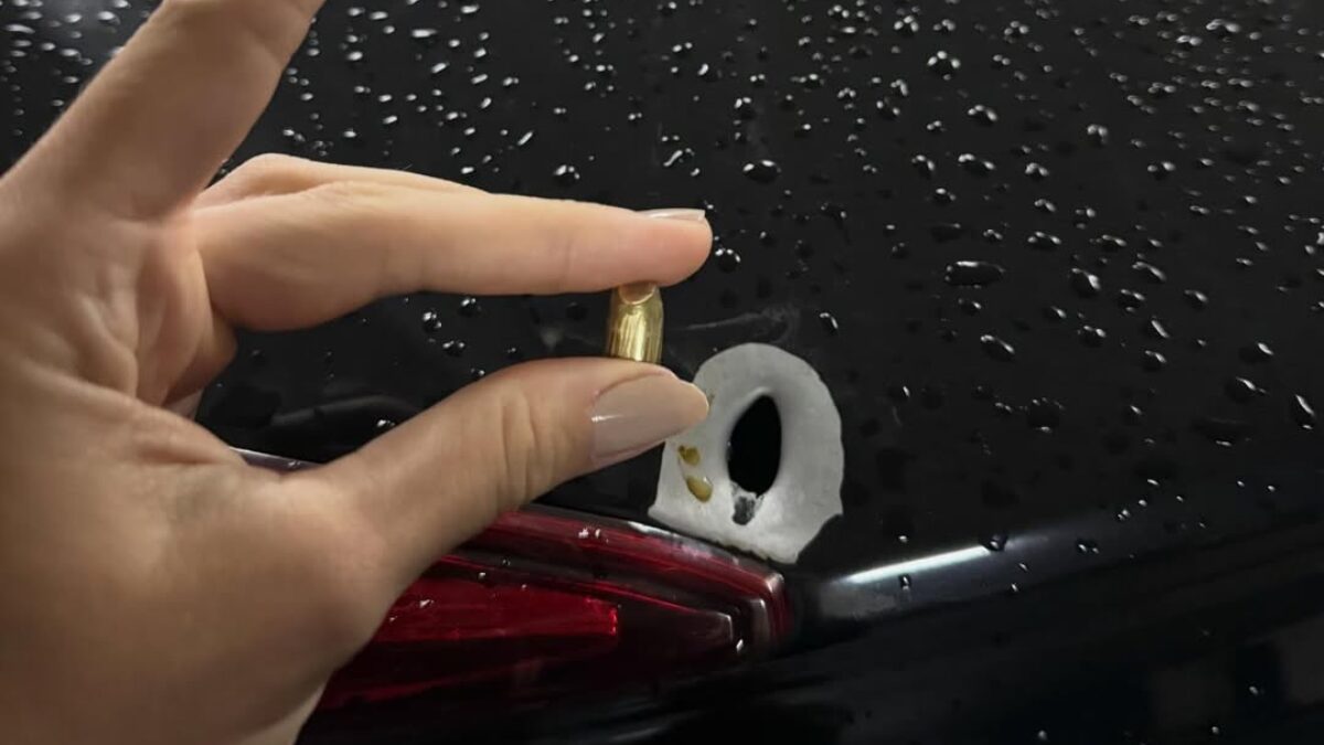 Júlia mostrando o projétil da bala e onde ficou na lataria do carro