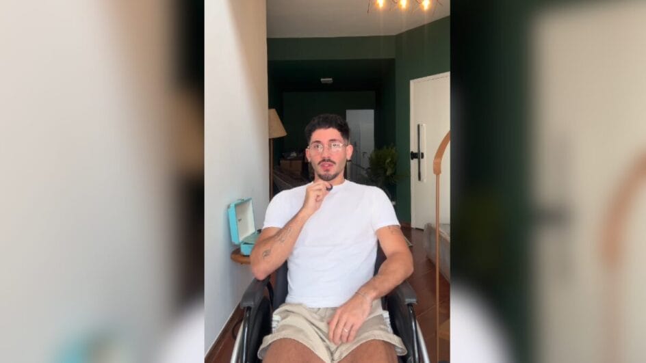 Foto mostra influenciador Vittor Fernando sentando em uma cadeira de rodas segurando um microfone