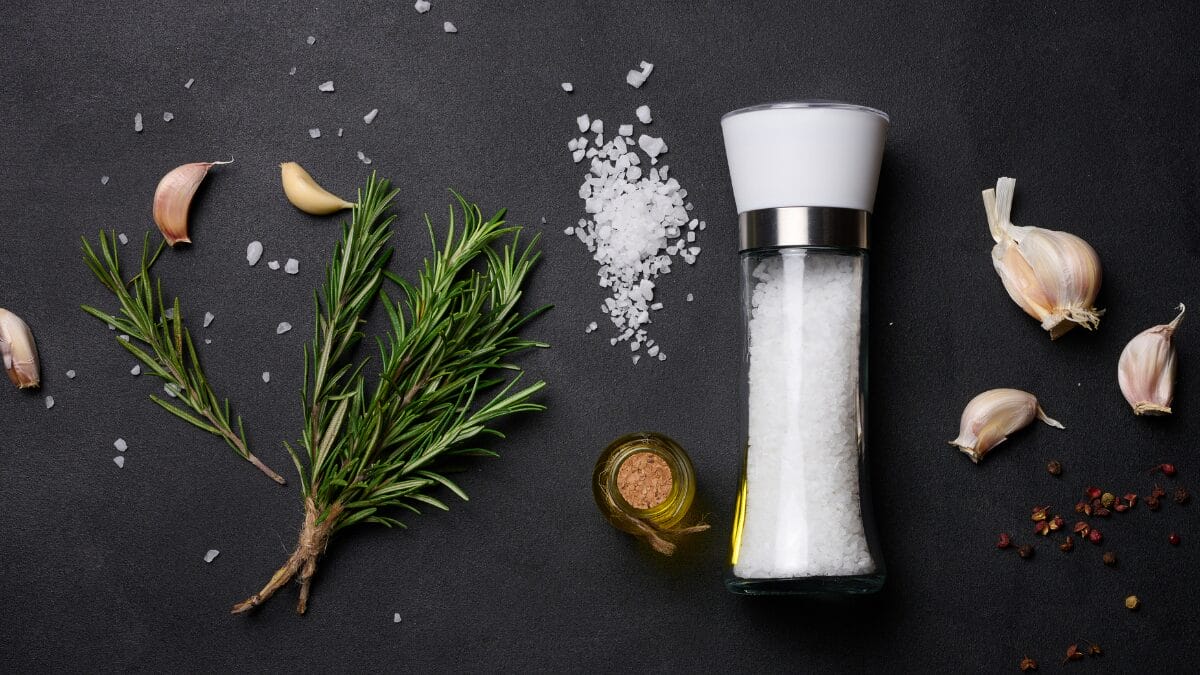 Vidro de sal grosso e ramos de alecrim