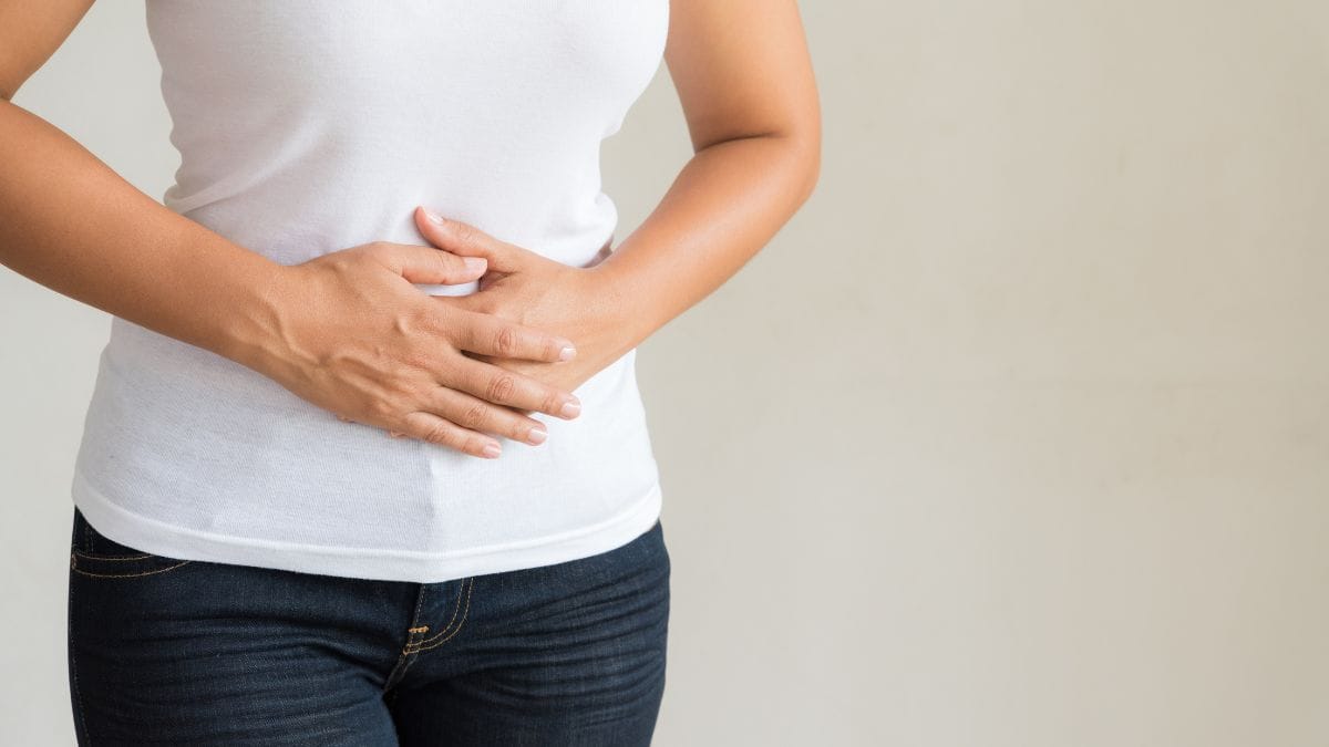mulher segurando a barriga com sensação de estufamento