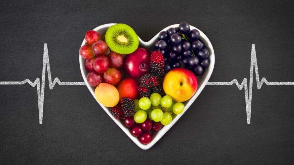 pote em formato de coração com várias frutas dentro e um desenho que lembra frequência cardíaca