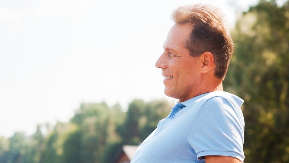 Homem olhando para o horizonte sorrindo