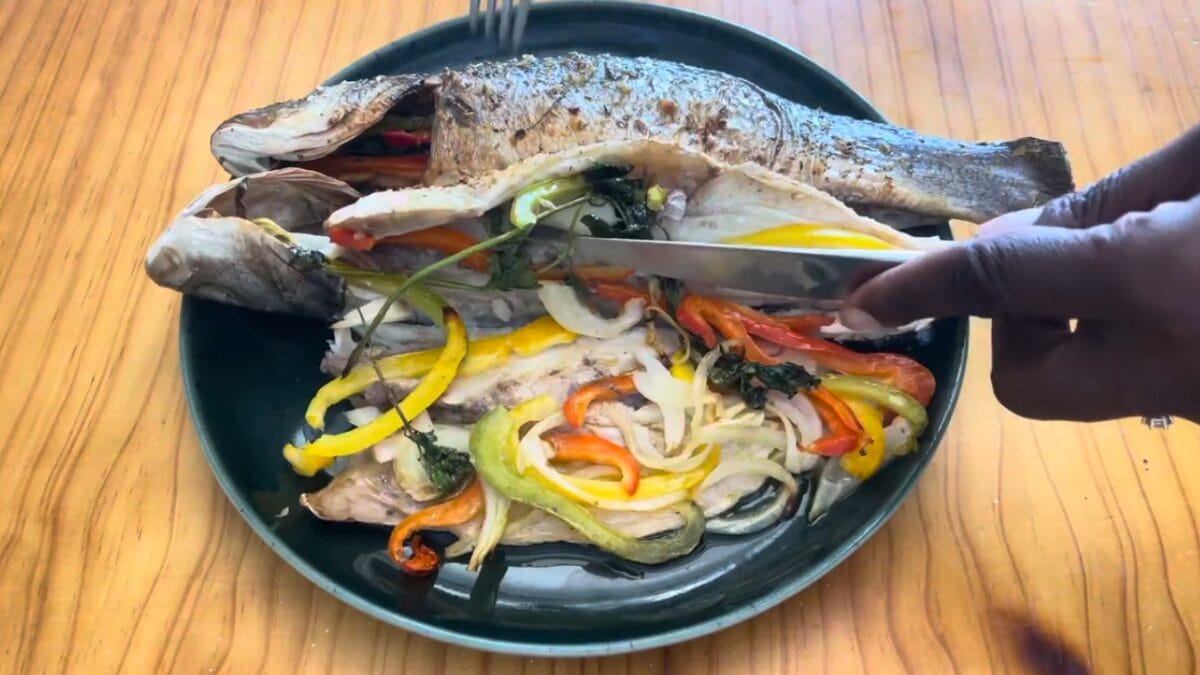 Imagem de peixe (robalo) sobre prato ocm diversos vegetais