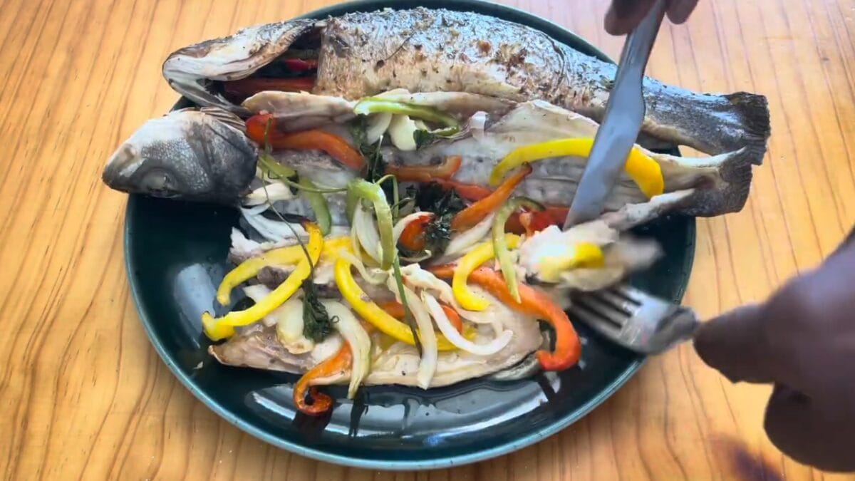 Imagem de peixe (robalo) sobre prato ocm diversos vegetais