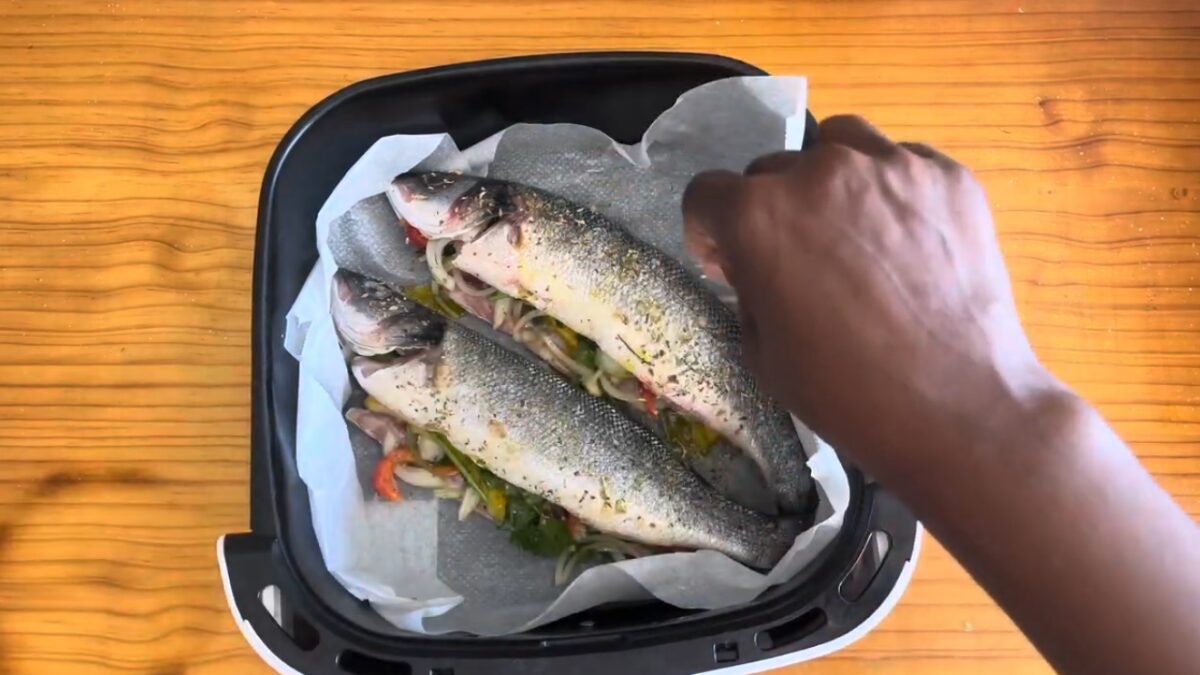 Imagem de peixe (robalo) em recipiente de air fryer ocm diversos vegetais