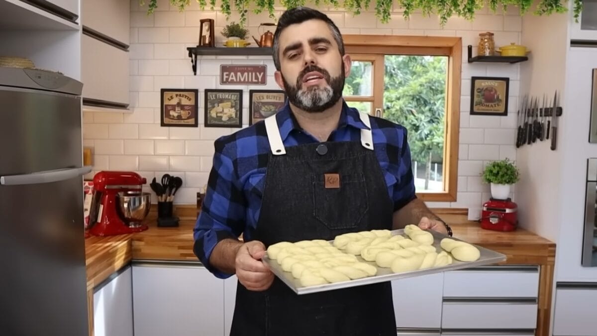 Homem de avental segura forma com massas pré-assadas em formato de trança