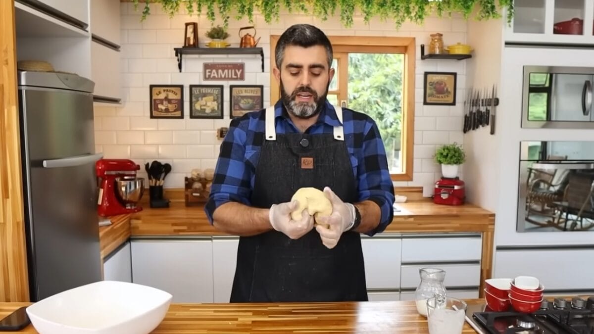 Homem sovando massa nas mãos 
