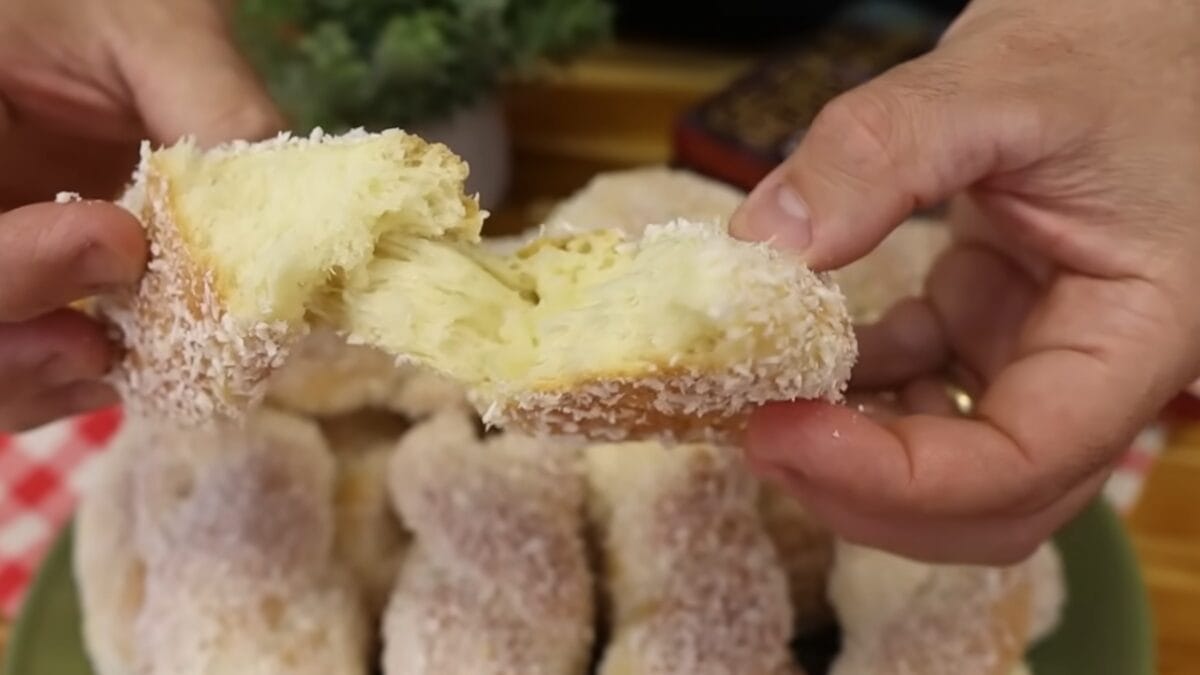 Homem mostra trancinha de coco, massa trançada assada