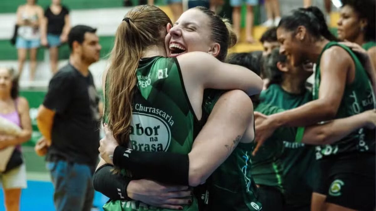 Atletas da equipe de voleibol de Chapecó de abraçando