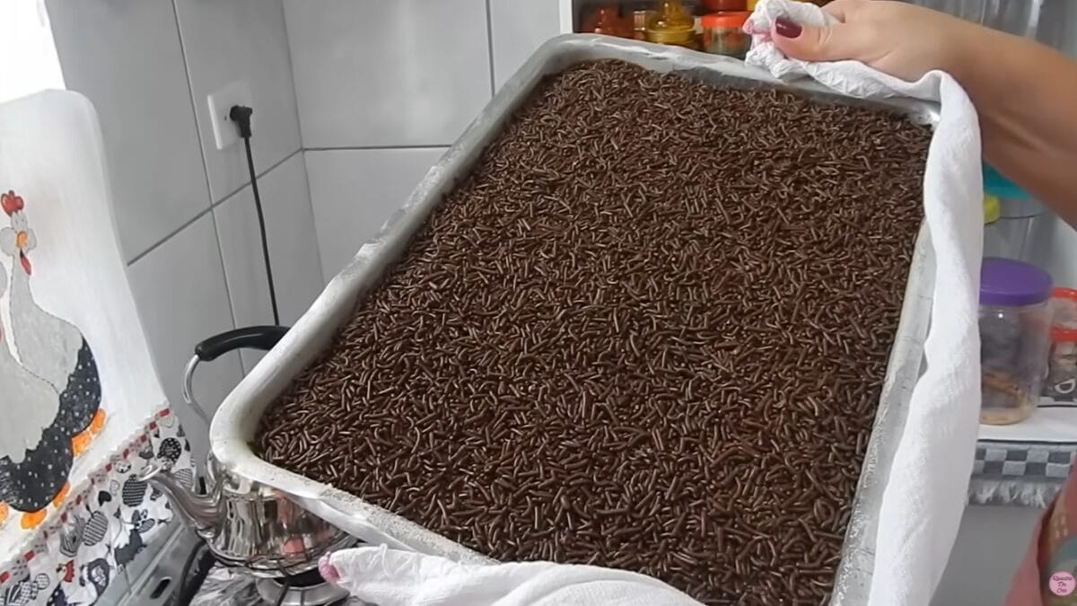 Assadeira grande cheia de bolo de chocolate coberto com granulado, recém-finalizado.