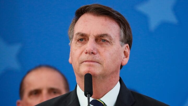 Foto mostra ex-presidente Jair Bolsonaro em frente à um microfone