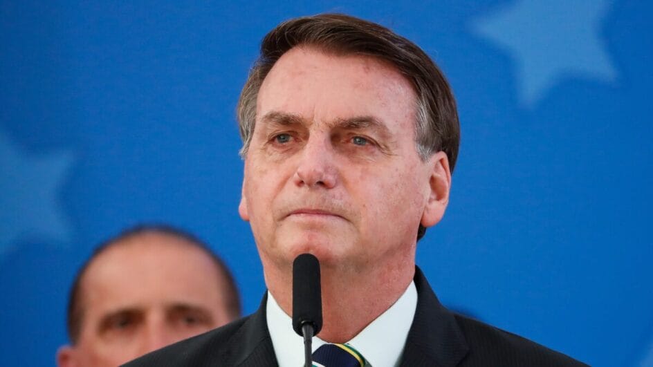 Foto mostra ex-presidente Jair Bolsonaro em frente à um microfone