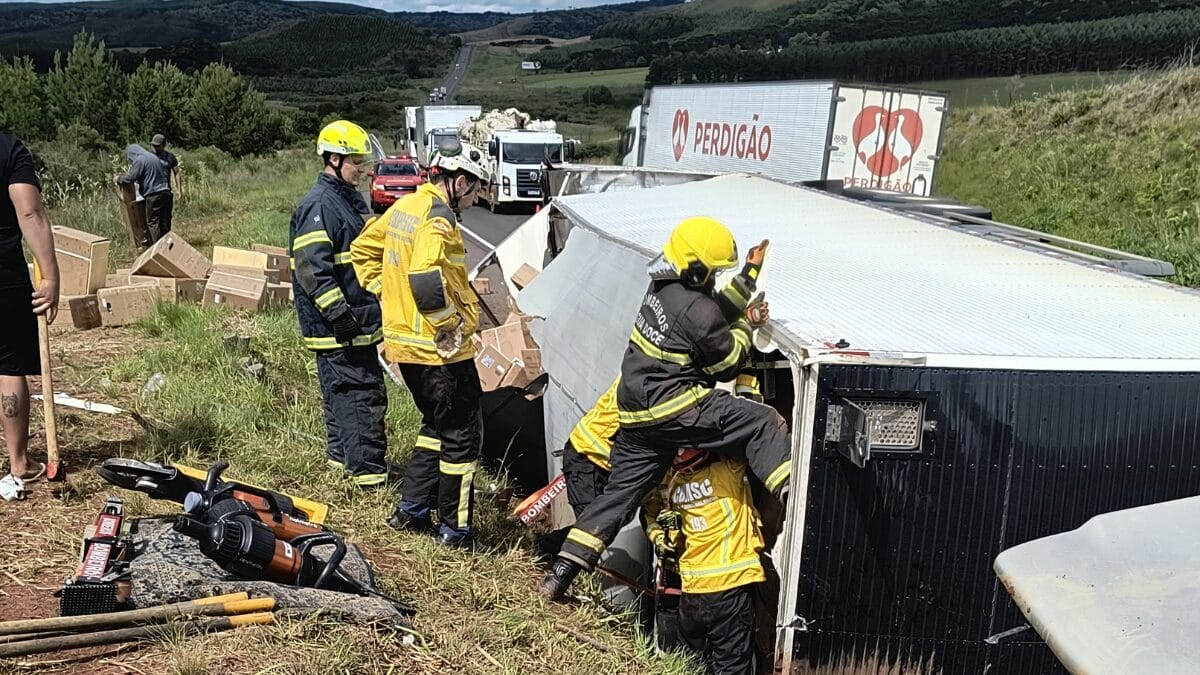 Bombeiros trabalham no caminhão tombado na quarta-feira (10) na BR-153, em Água Doce, com parte da carga caída ao lado da rodovia.