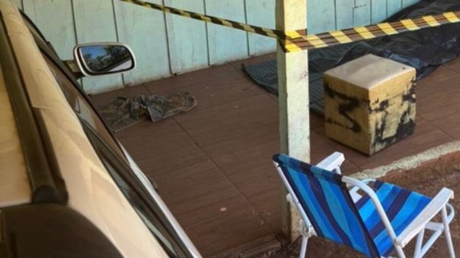 Varanda de casa de madeira isolada com fita zebrada. Casa em Palmitos foi cenário de crime.