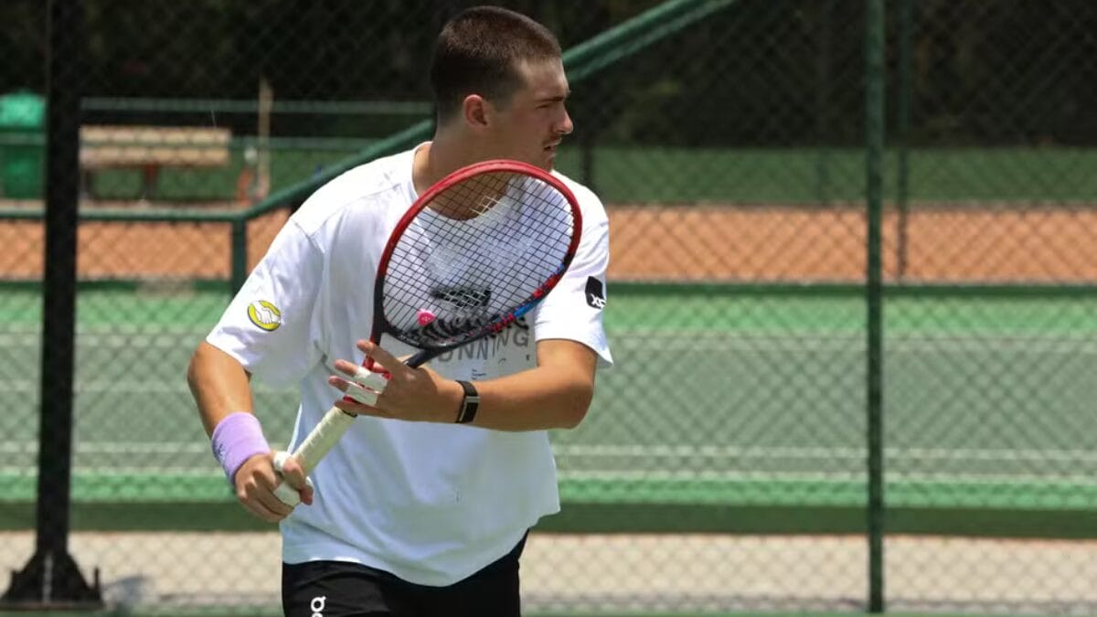 João Fonseca com a raquete na mão em treino e de cabelo raspado