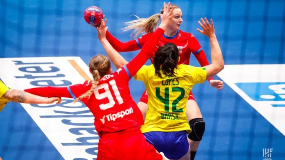 Jogadora da Tchéquia com a bola na mão e defesa do Brasil na frente pelo Mundial de Handebol Feminino