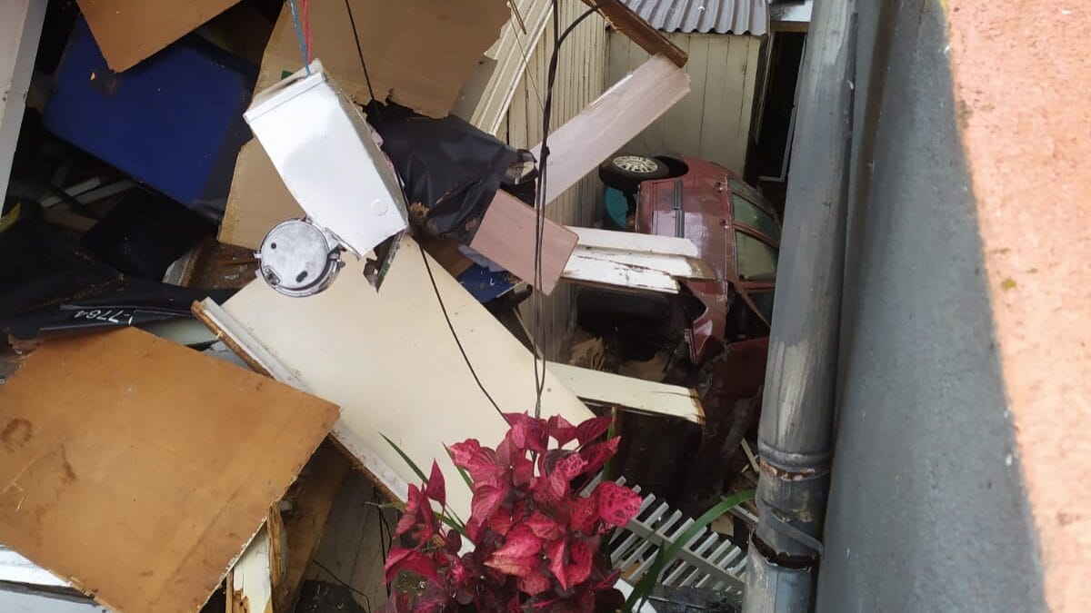 Estrutura de casa destruída após acidente em 9/12/2025 em Joaçaba, com escombros acumulados e veículo capotado ao fundo.