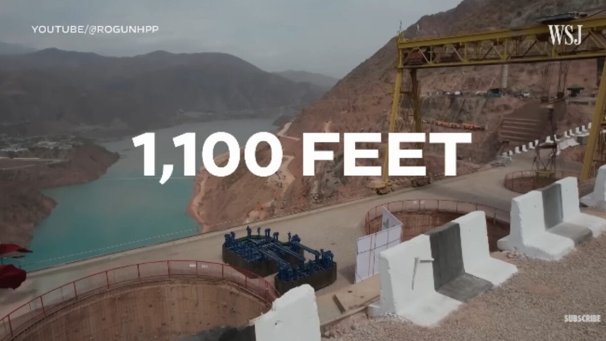 Imagem do local de construção da barragem com o texto '1,100 FEET' sobreposto, indicando a altura planejada da estrutura.