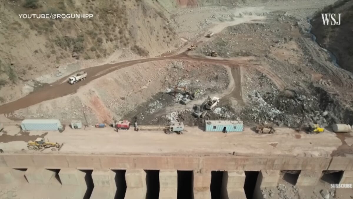 Vista superior de veículos de construção, contêineres e equipamentos sobre a estrutura de concreto com aberturas.