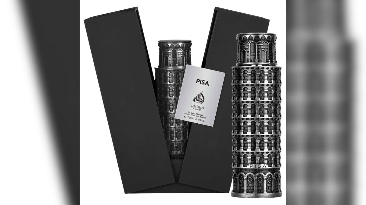 Frasco de perfume "Pisa" da linha Lattafa Pride. O frasco possui um design metálico prateado e escultural no formato exato da Torre de Pisa, posicionado ao lado de sua caixa preta aberta com interior aveludado.