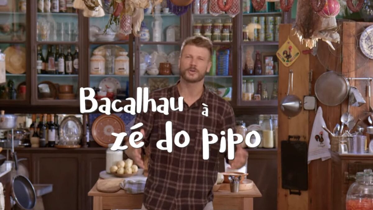 Apresentador Rodrigo Hilbert posando em cozinha com o texto "Bacalhau a Z&eacute; do Pipo" escrito