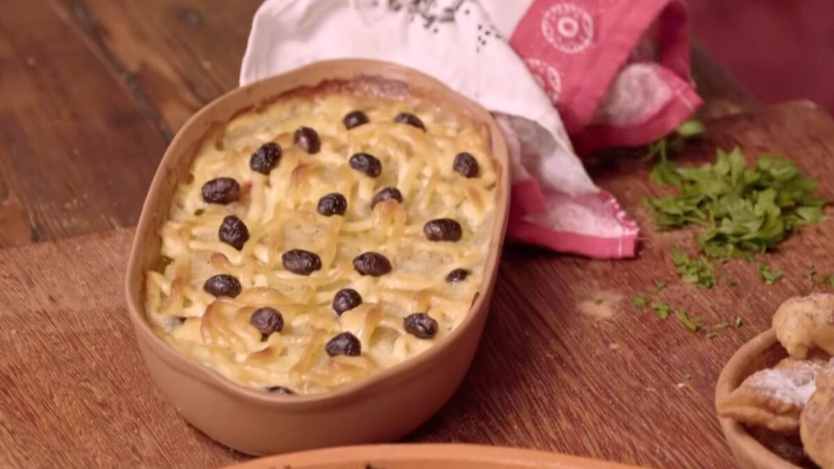 Prato com bacalhau, batatas e decorado com azeitonas pretas servido em travessa oval 