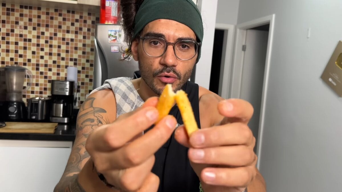 Homem quebrando batata frita ao meio