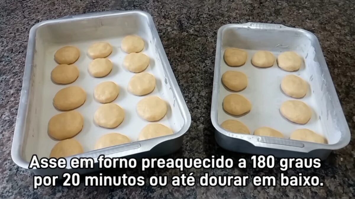 Massa de bolacha caseira moldada em pequenas porções em duas formas retangulares, pronta para assar em forno preaquecido a 180 graus.