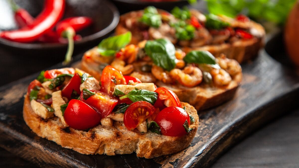 Bruschetta com tomates frescos, manjericão e azeite sobre pão crocante, receita simples e saborosa da culinária italiana.