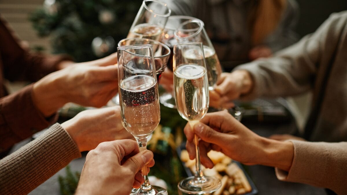 Brinde com taças de espumante em celebração de fim de ano, cenário típico de Natal e Ano Novo.