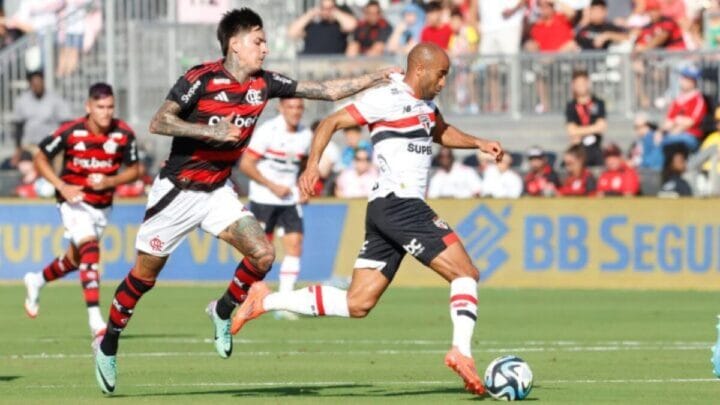 Jogador do Flamengo e do São Paulo em disputa de bola, durante jogo.