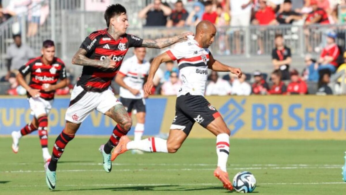 Jogador do Flamengo e do São Paulo em disputa de bola, durante jogo.