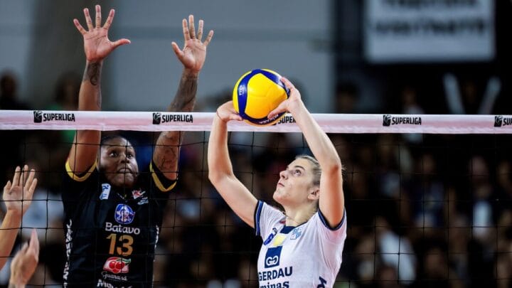 Jogadora do Minas levantando bola enquanto atleta do Mackenzie levanta para bloquear