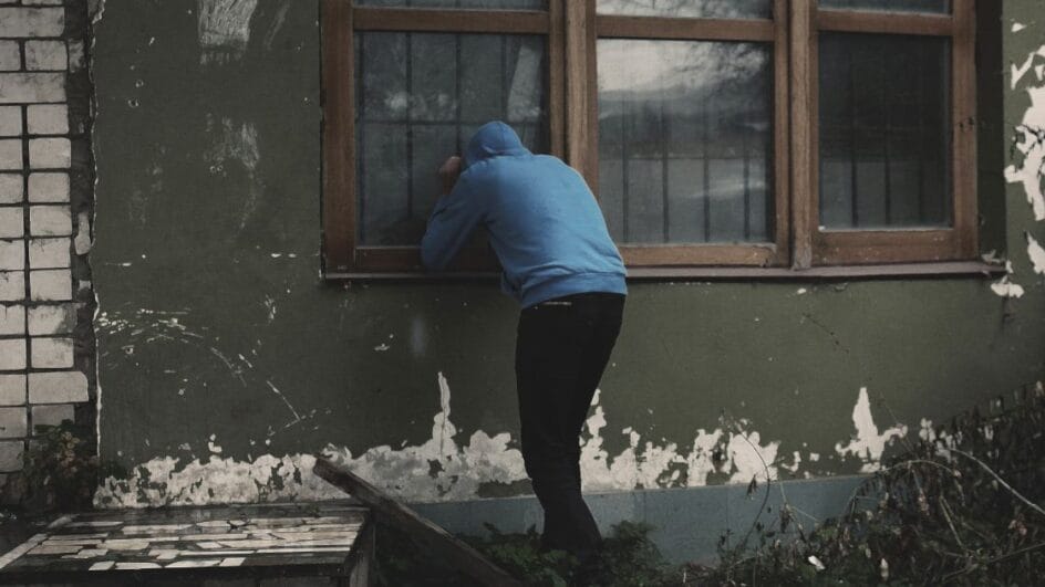 Homem invadindo uma casa pela janela