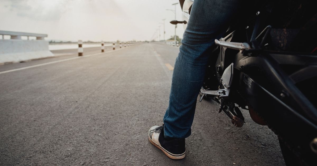 Motociclista com um dos pés no chão
