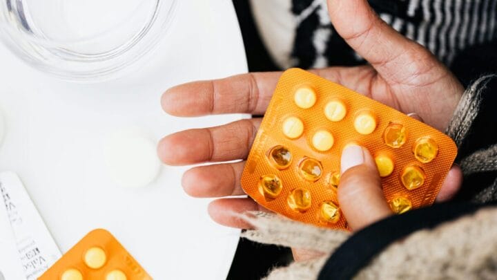 Pessoa tomando remédio em comprimido