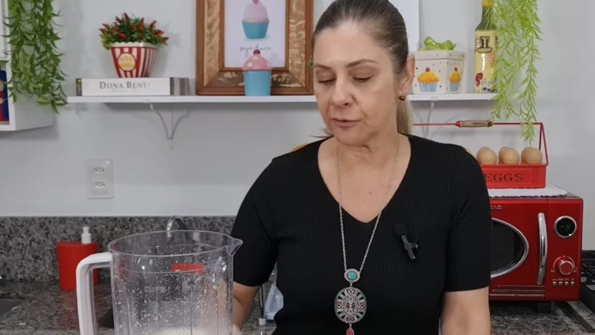 Pessoa preparando massa de bolo de amido de milho no liquidificador em cozinha caseira