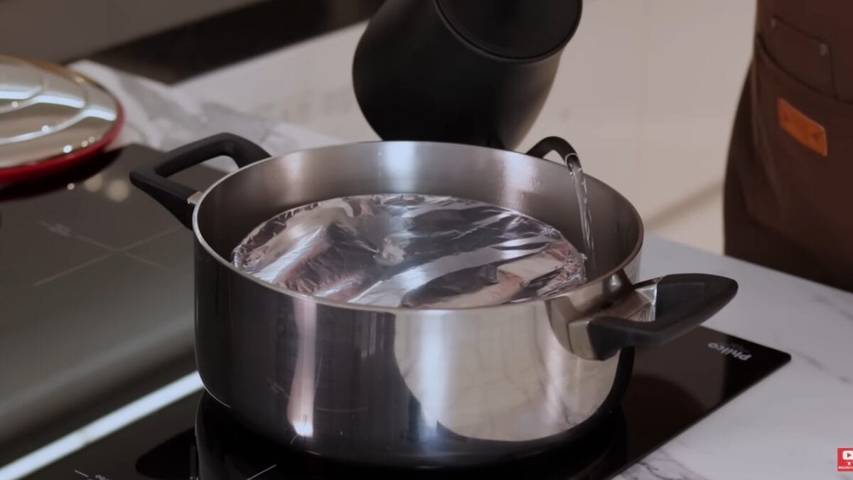 Preparo de doce de leite em banho-maria no fog&atilde;o com forma coberta