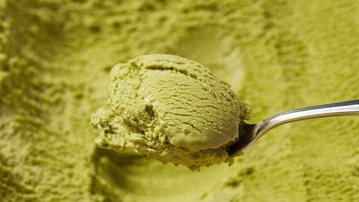 Colher com gelato italiano verde mostrando textura densa e cremosa da sobremesa