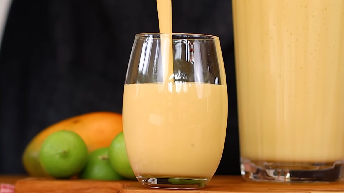 Limonada alemã sendo despejada em copo de vidro, mostrando consistência cremosa da bebida feita no liquidificador