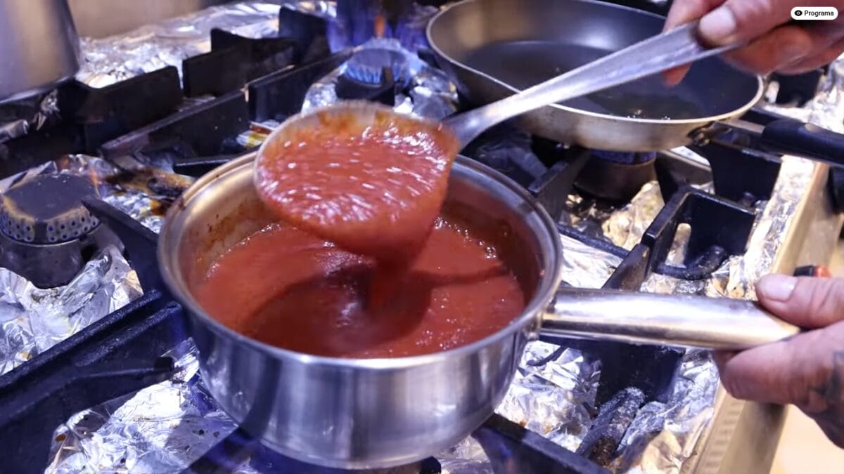 Molho de tomate caseiro sendo cozido em panela no fog&atilde;o com textura encorpada