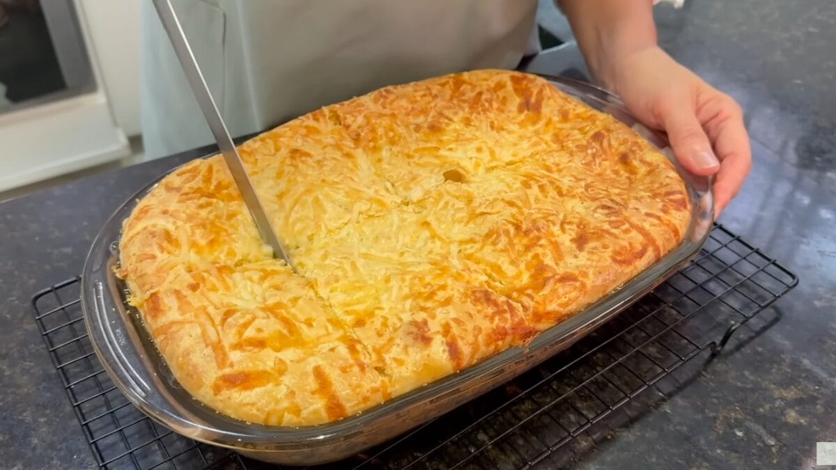 Corte da torta de frango cremosa de liquidificador ainda quente