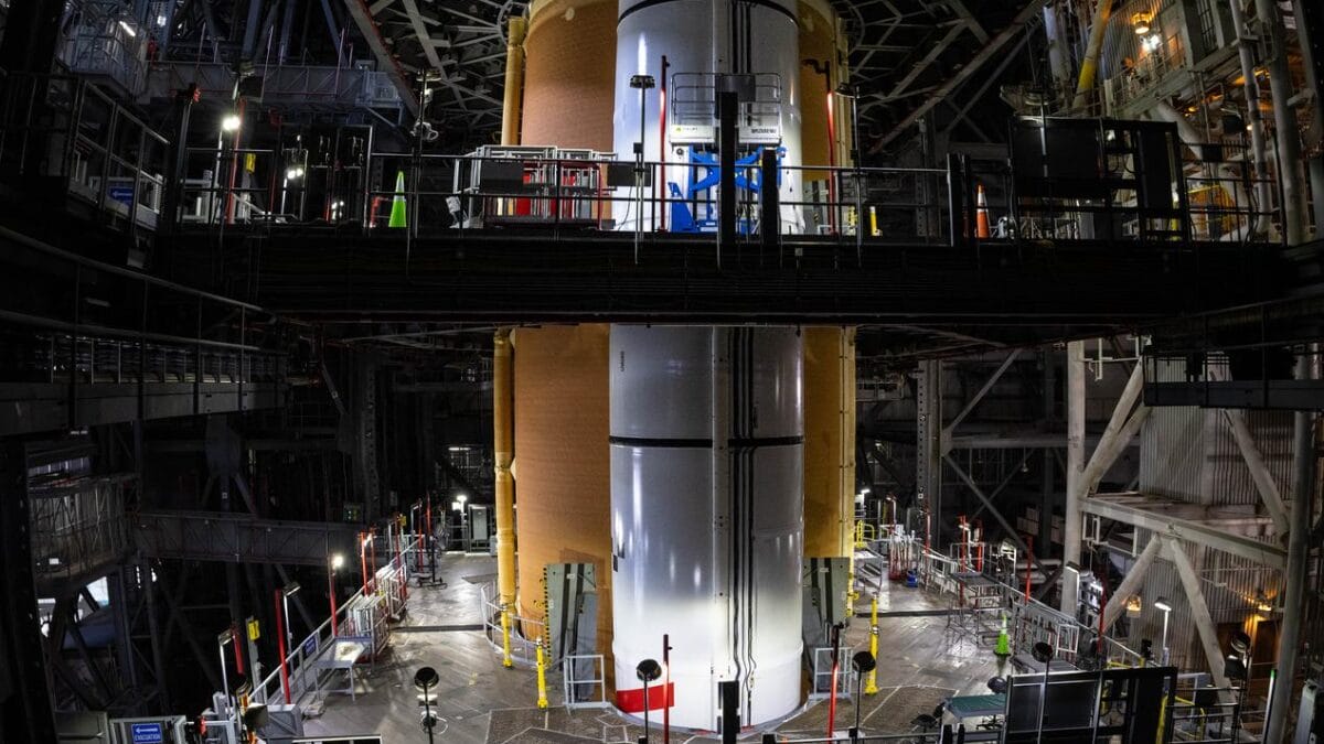 O foguete Artemis II SLS (Space Launch System) da NASA, com seu estágio superior de propulsão criogênica (o estágio intermediário) no topo, está posicionado no prédio de montagem de veículos do Centro Espacial Kennedy da NASA, na Flórida, na quinta-feira, 24 de julho de 2025. A missão Artemis II é o primeiro voo tripulado do programa Artemis da NASA e representa mais um passo rumo a missões na superfície lunar, além de auxiliar a agência na preparação para futuras missões humanas a Marte.