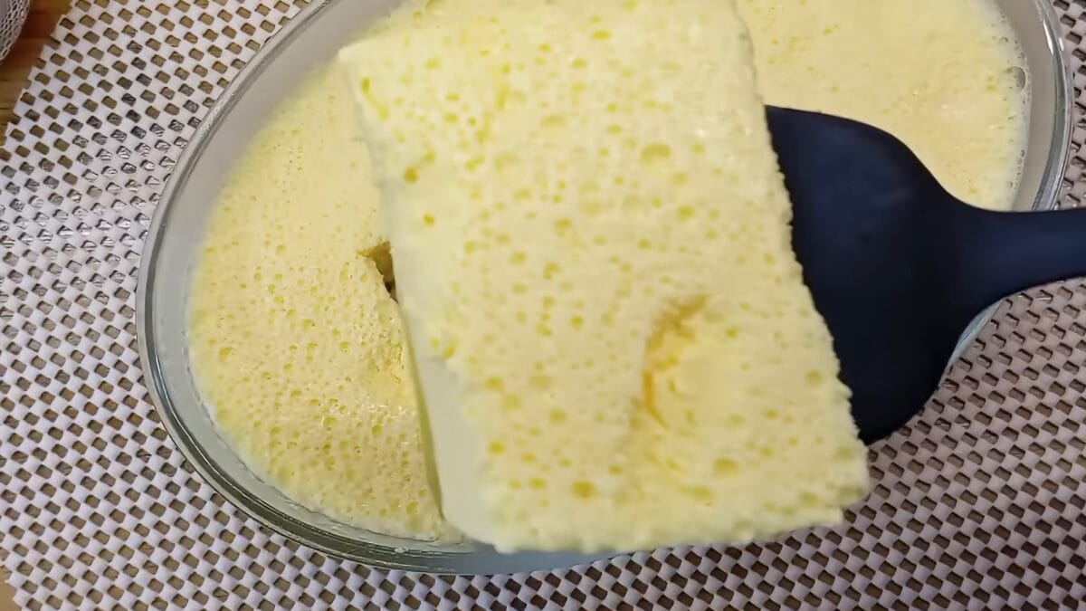 Colher retirando pedaço de sobremesa gelada cremosa com camada amarela