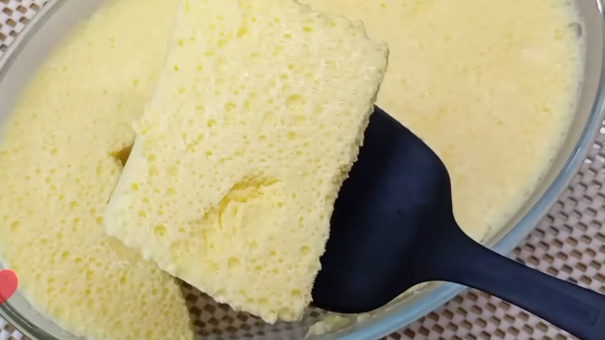 Colher retirando pedaço de sobremesa gelada cremosa com camada amarela