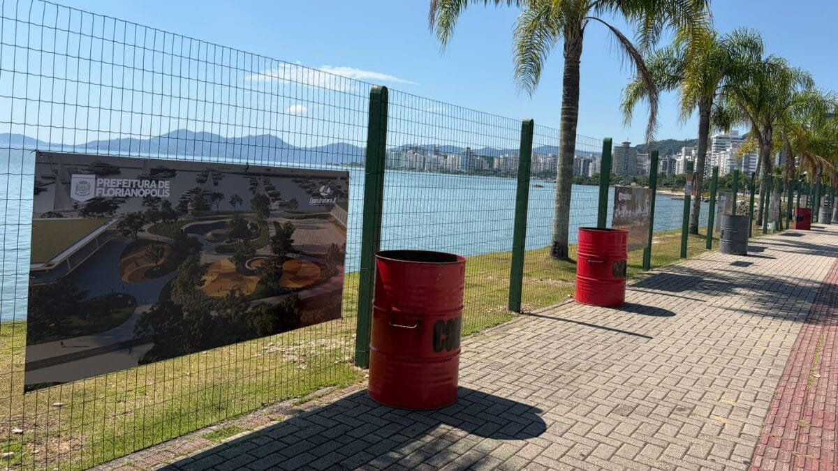 Tapumes com imagens do projeto do novo parque da Beira-Mar Norte instalados ao longo do cal&ccedil;ad&atilde;o, com vista para o mar.