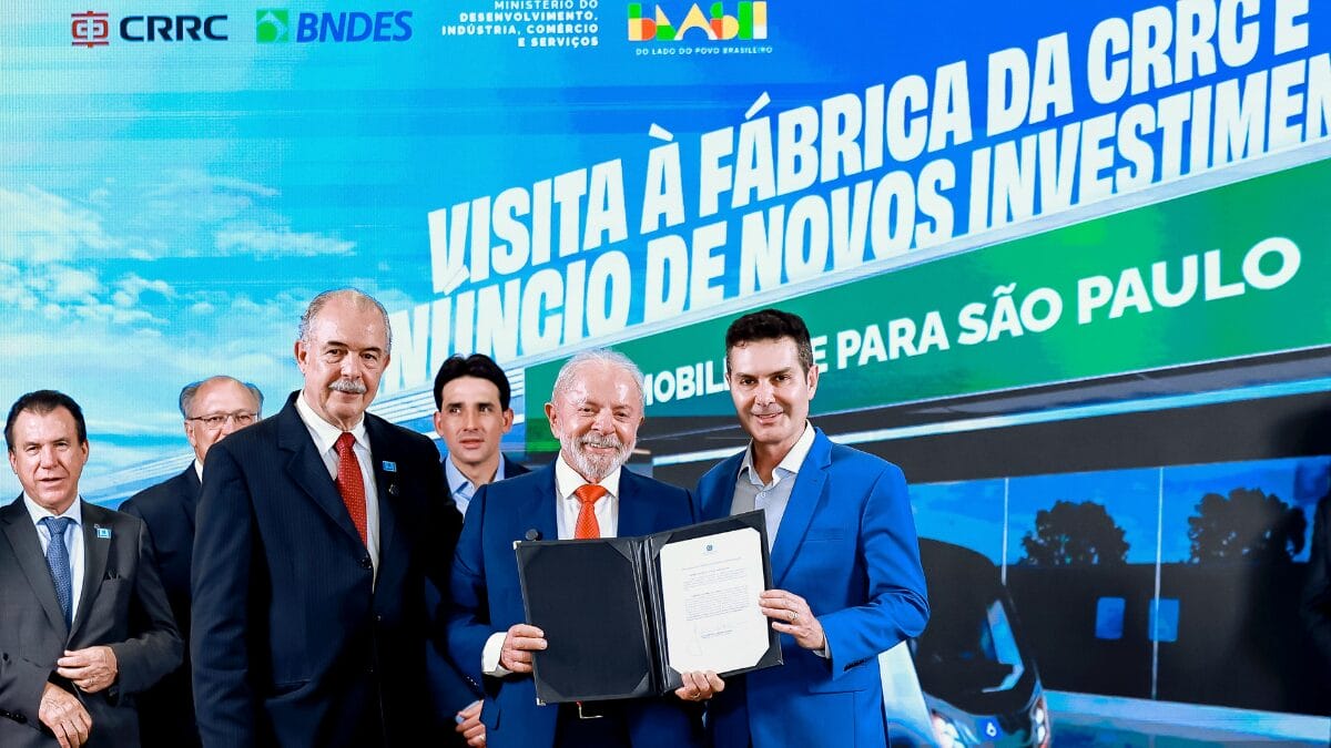 Lula e executivos seguram documento oficial durante cerim&ocirc;nia na f&aacute;brica da CRRC, em Araraquara.