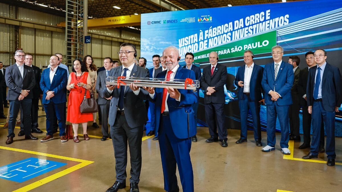 Lula observa r&eacute;plica de trem ao lado de executivo chin&ecirc;s durante apresenta&ccedil;&atilde;o t&eacute;cnica.