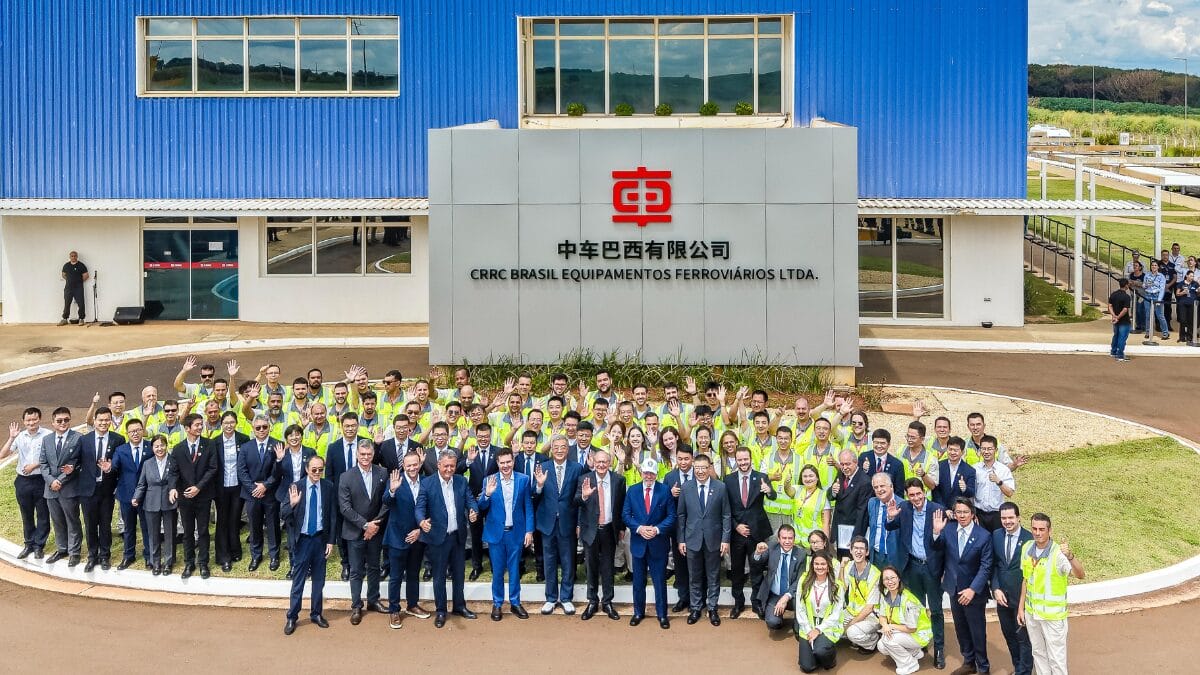 Grupo de funcion&aacute;rios, executivos e autoridades reunidos em frente ao pr&eacute;dio da CRRC Brasil.