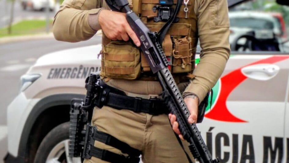 Imagem mostra agente de segurança pública segurando arma de fogo